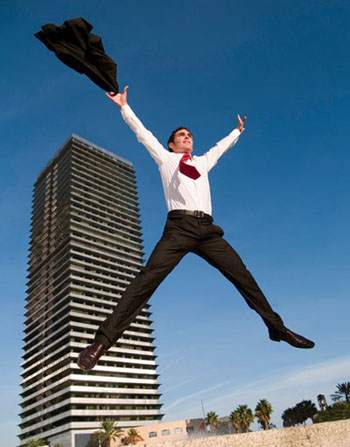 Man in Suit jumping in front of business building
