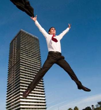 Man in Suit jumping in front of business building